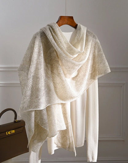 Ivory cashmere shawl styled over a cream top with an asymmetrical drape and long hanging ends.