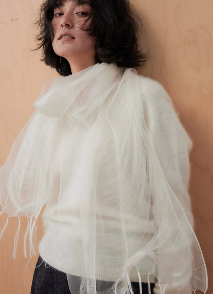 Flowing ivory white silk fringe scarf layered over a tonal cream outfit