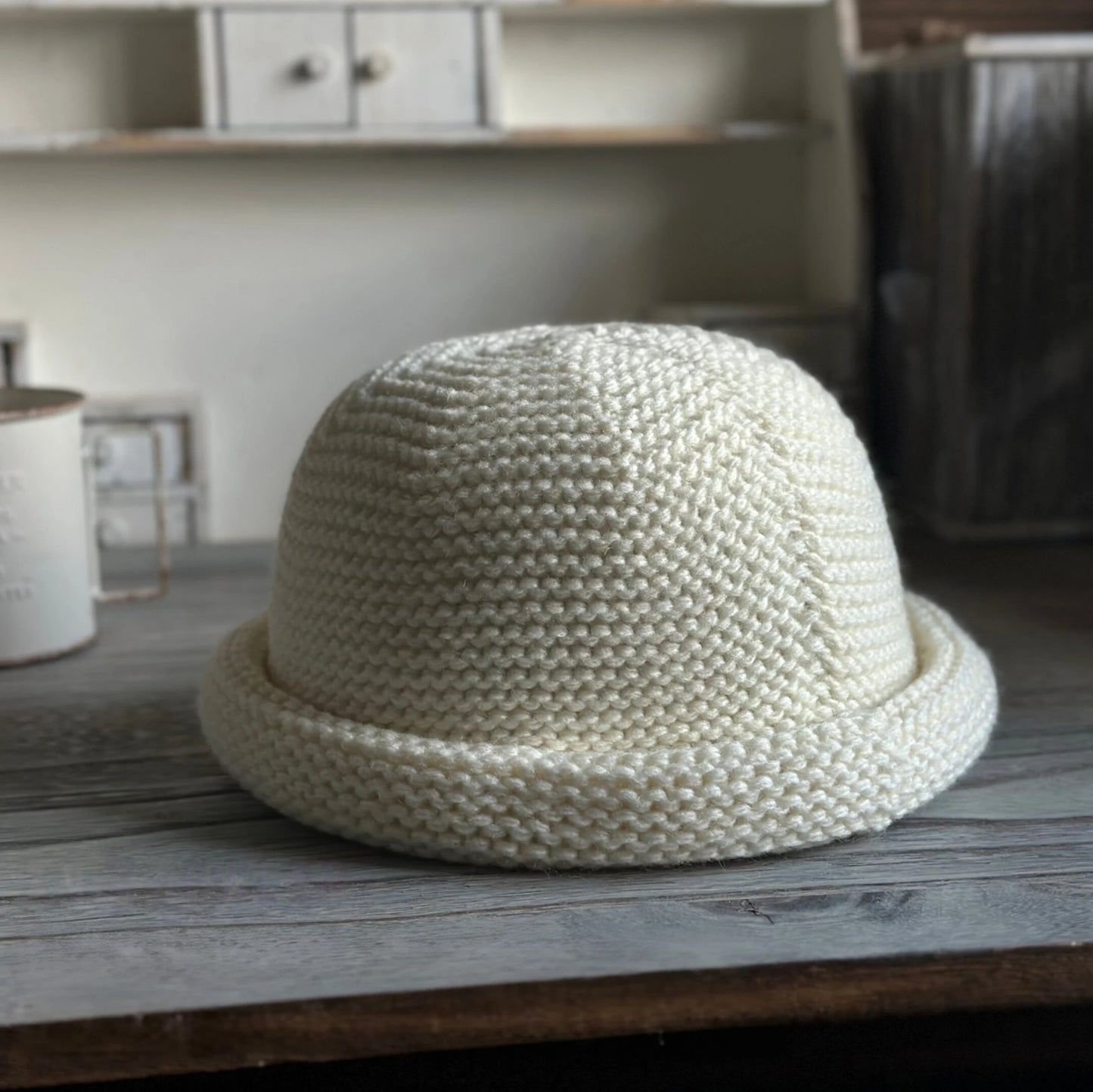 Front view of an ivory rolled brim knit hat with a sculpted dome crown and textured stitching