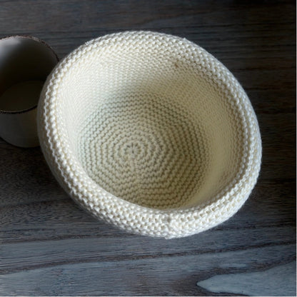 Interior view of an ivory wool blend knit beanie showing spiral construction and a rolled brim