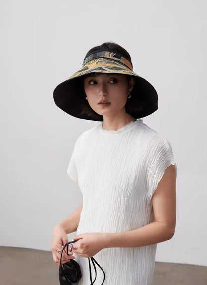 Model wearing a vintage jacquard wide brim sun visor hat with open top design for resort and beach styling.