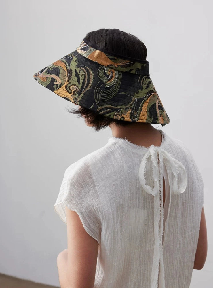 Back view of foldable jacquard sun visor hat with wide brim and adjustable open top fit.