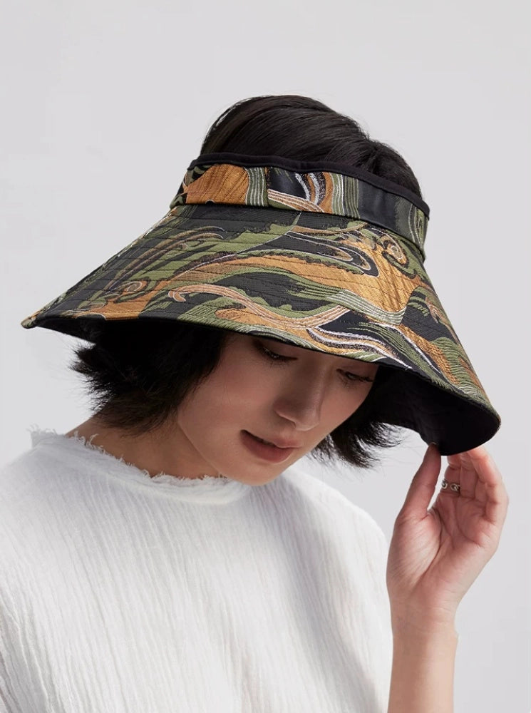 Woman styling a jacquard open top sun visor hat with wide brim for summer outdoor wear.