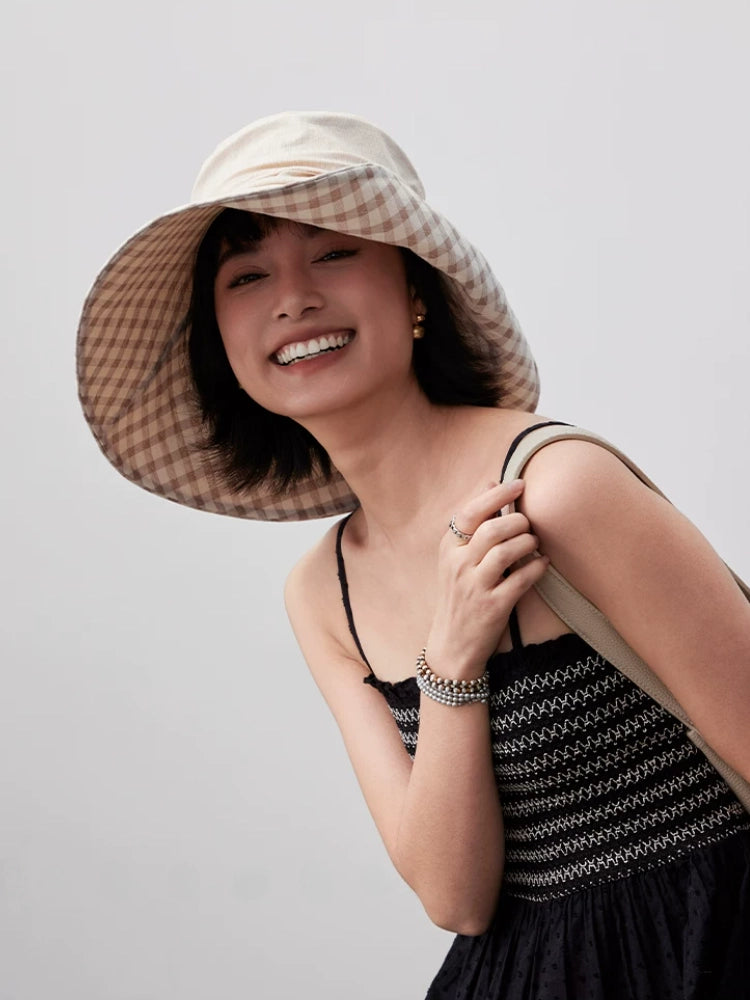 Smiling woman wearing khaki wide brim summer hat with gingham plaid lining and wind cord