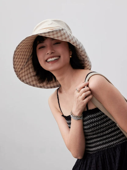 Smiling woman wearing khaki wide brim summer hat with gingham plaid lining and wind cord