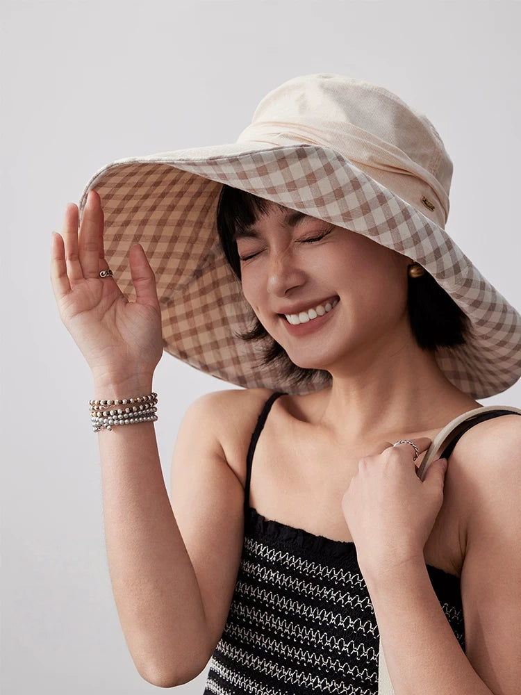 Woman styling khaki cotton wide brim sun hat with plaid lining for summer outdoor wear