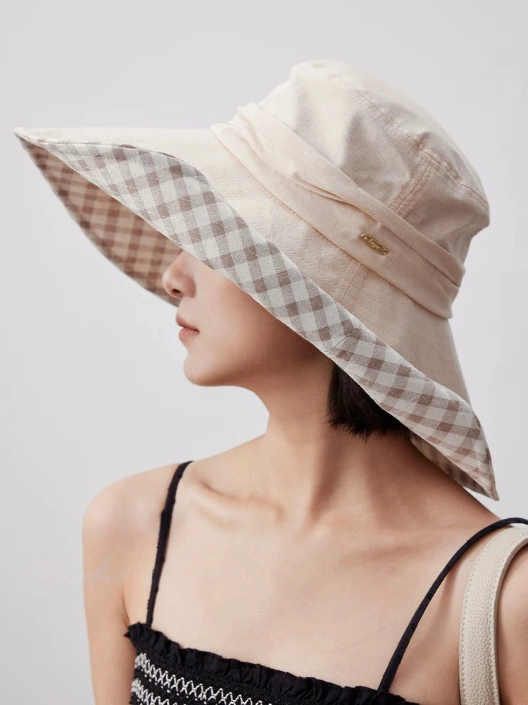 Woman wearing khaki plaid lining sun hat with wide brim for beach, garden, and travel