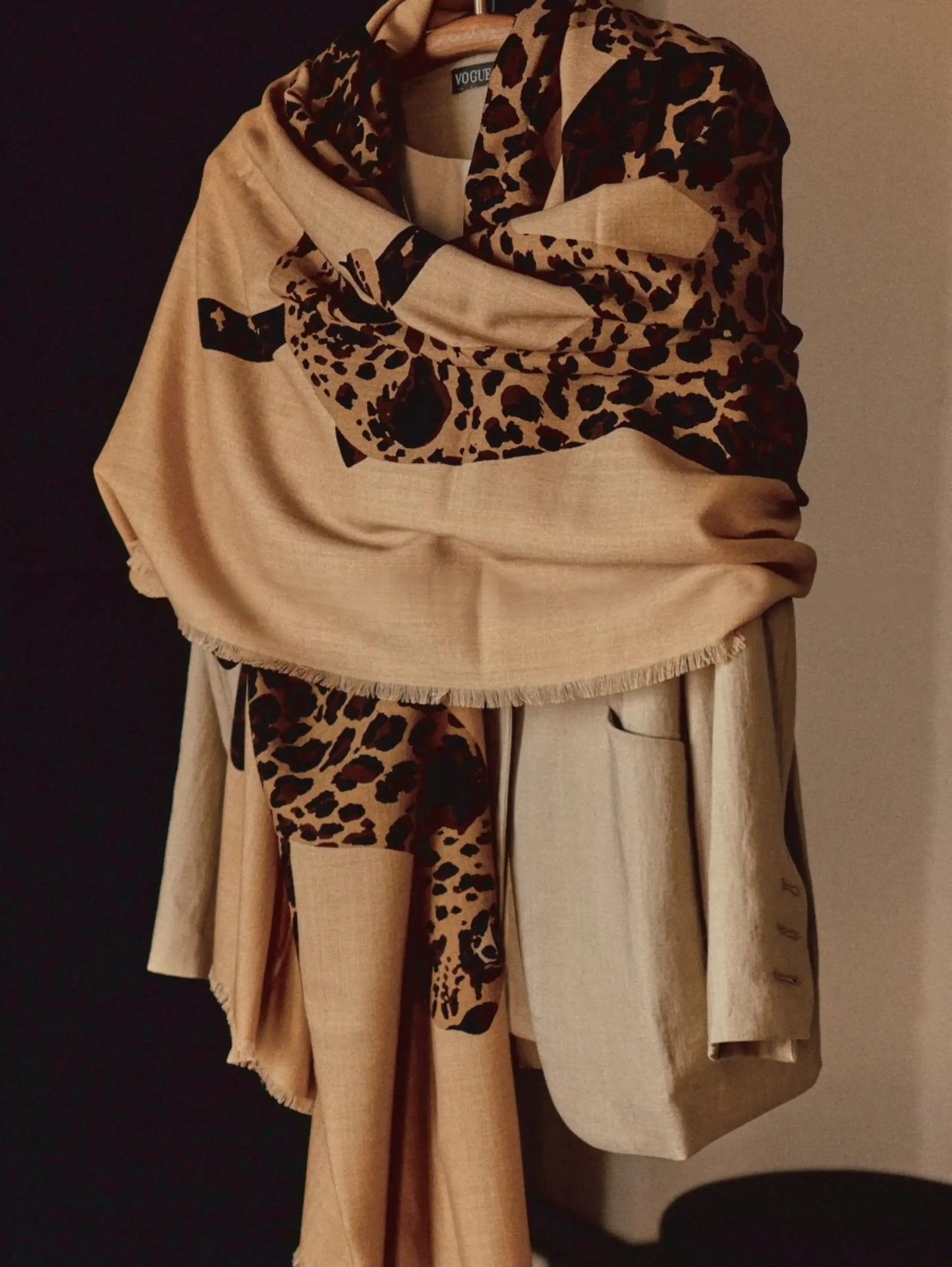 Khaki leopard print wool scarf wrapped around the shoulders over a neutral layered outfit