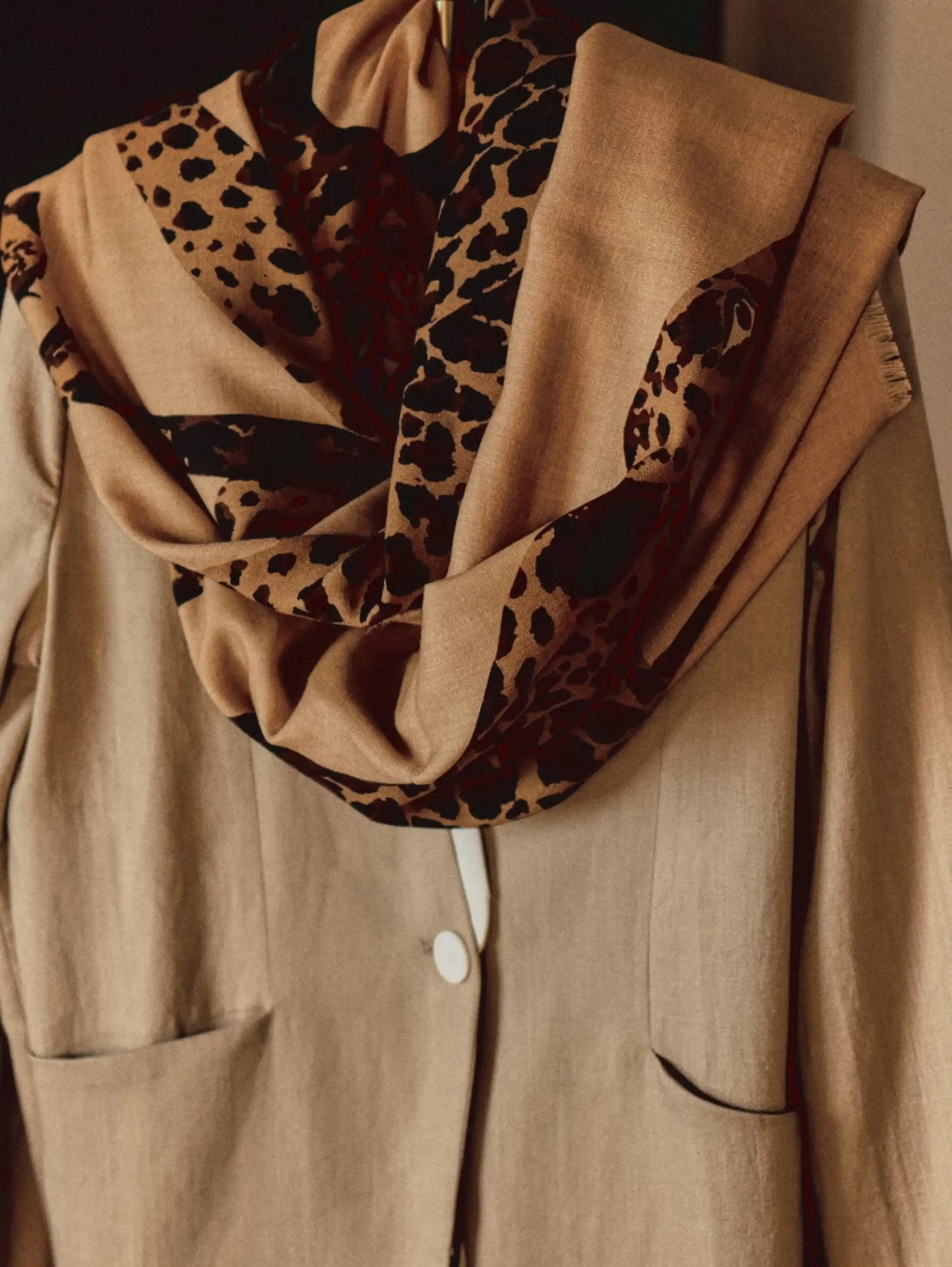 Khaki leopard print wool scarf draped loosely around the neck for relaxed everyday styling