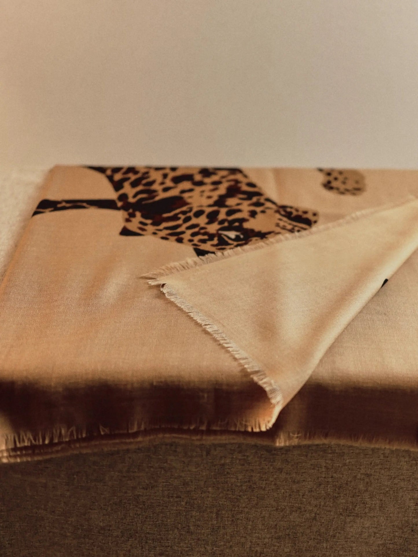 Folded 100% wool scarf in khaki with leopard artwork and a softly fringed edge