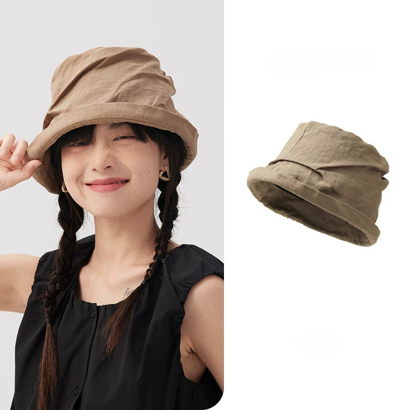Khaki crinkled linen bucket hat with rolled short brim, shown on model with product view