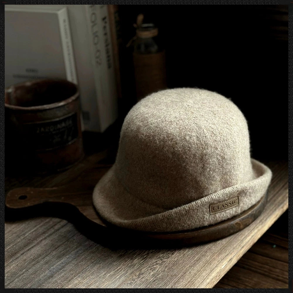 Khaki women's wool felt cloche hat with a rounded dome crown, rolled brim and logo patch