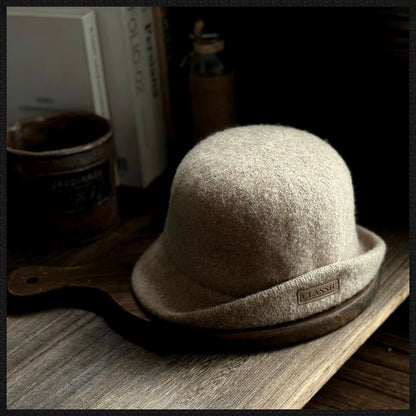 Khaki women's wool felt cloche hat with a rounded dome crown, rolled brim and logo patch