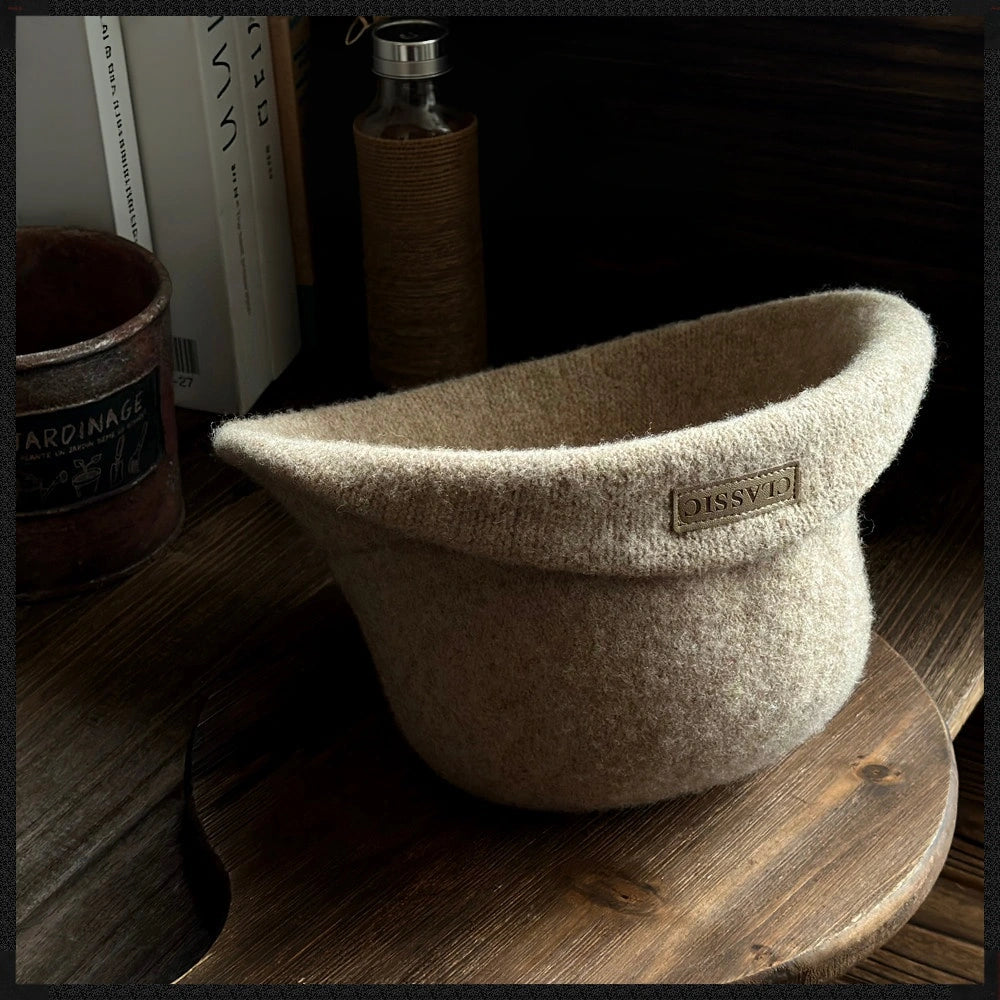 Side view of a khaki rolled brim wool cloche hat showing its soft felt texture and logo patch