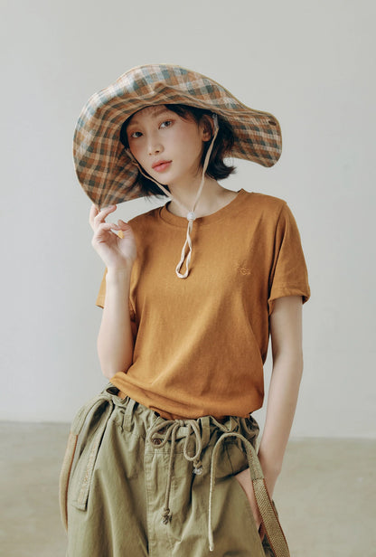 Plaid wide brim outdoor sun hat with string, worn with casual utility outfit for vintage cargo style.