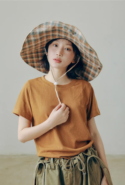 Plaid wide brim outdoor sun hat with chin string, worn with casual cargo outfit for city outdoor style.