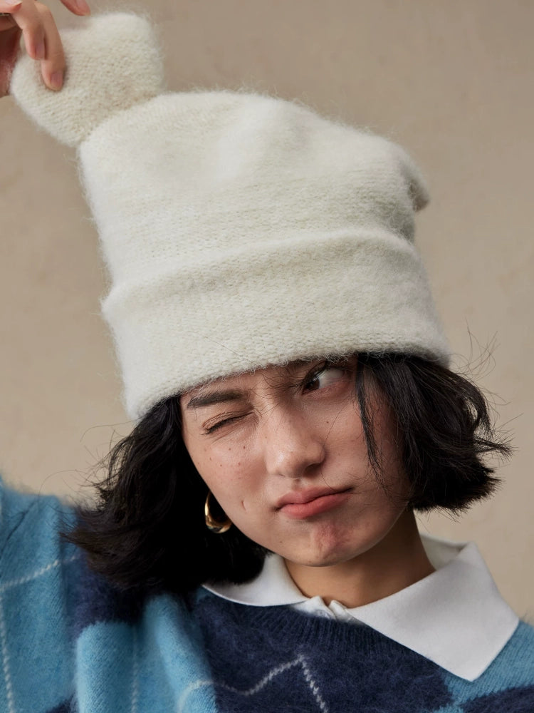 Cream white koala ear knit beanie with one rounded ear lifted by the model.