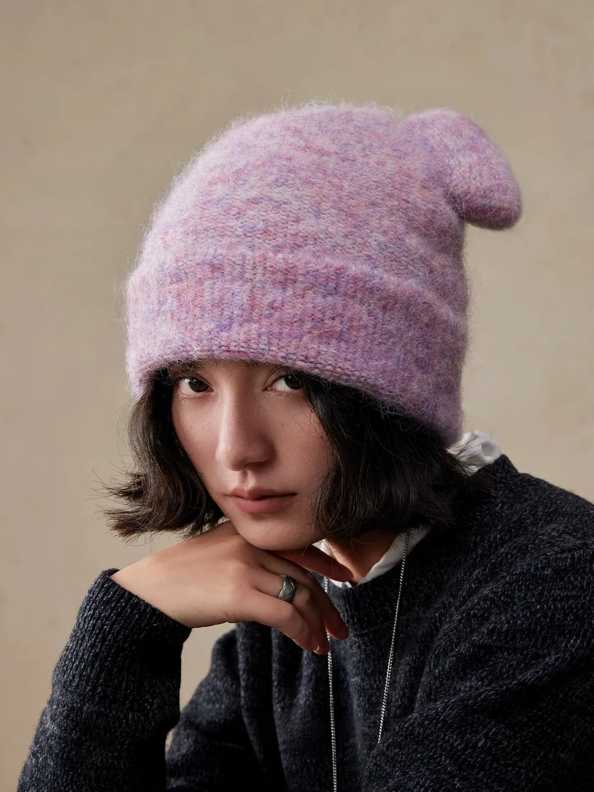 Front view of a misty lavender koala ear knit beanie worn low over the forehead.