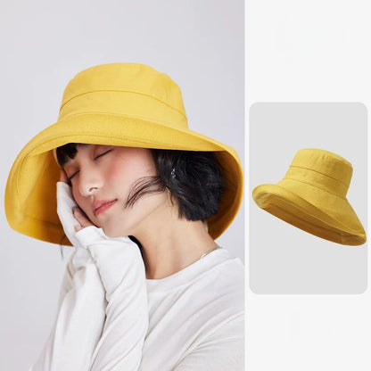 Woman wearing a lemon yellow linen blend wide brim sun hat with a relaxed bucket-style silhouette