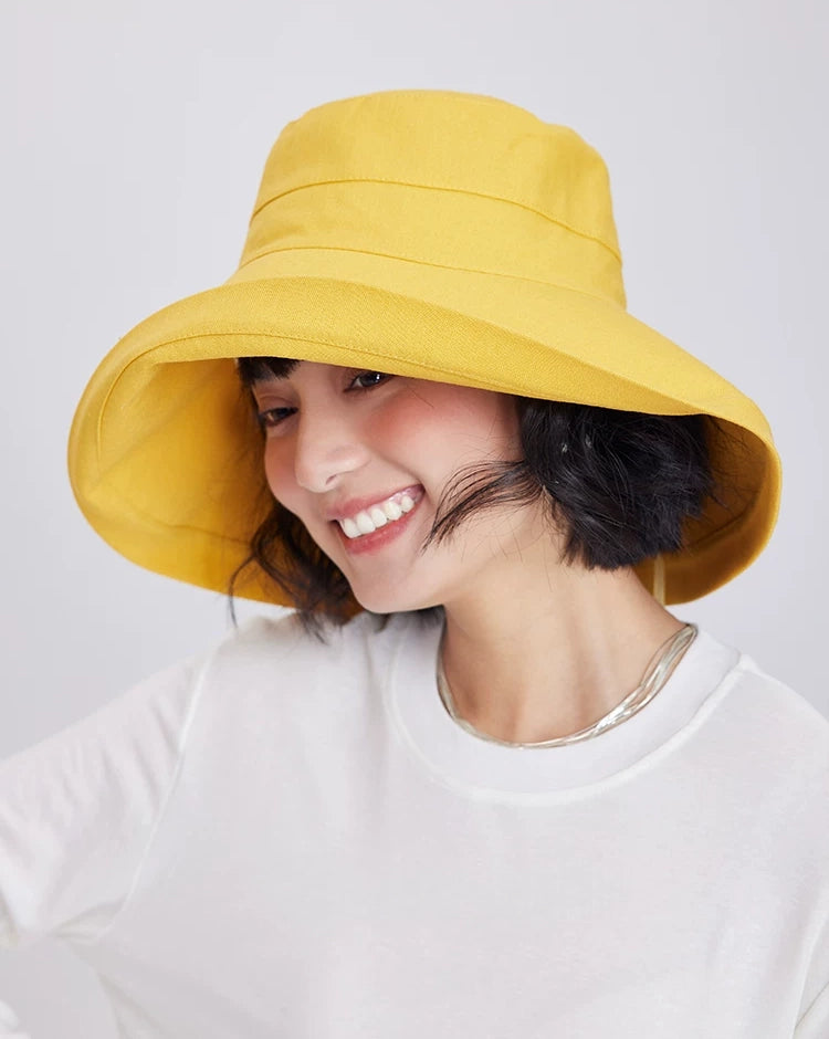 Front view of a lemon yellow linen cotton sun hat with a softly curved wide brim