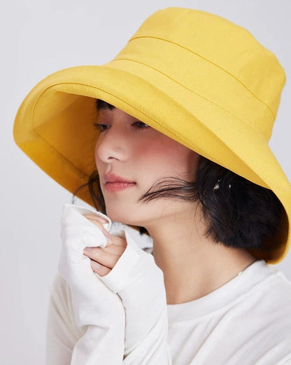 Side view of a lemon yellow wide brim bucket sun hat styled for summer travel and beach wear