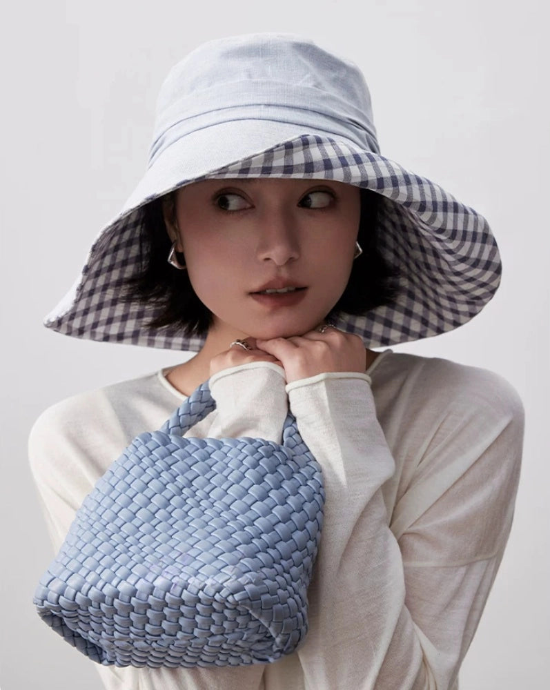 Light blue wide brim summer hat with plaid lining styled with white outfit and woven bag