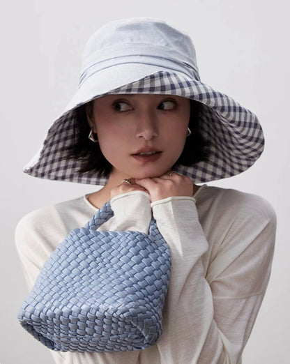 Light blue wide brim summer hat with plaid lining styled with white outfit and woven bag