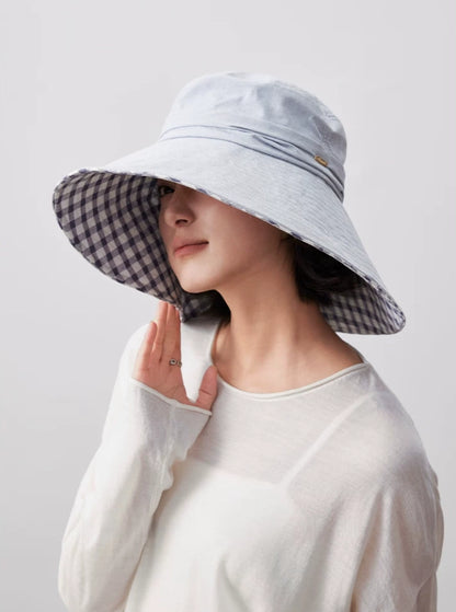 Side view of light blue cotton floppy sun hat with oversized brim and gingham plaid lining
