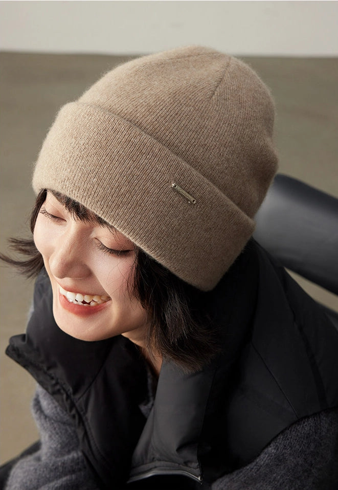 Side-view portrait of a woman wearing a light coffee 100% cashmere cuffed beanie