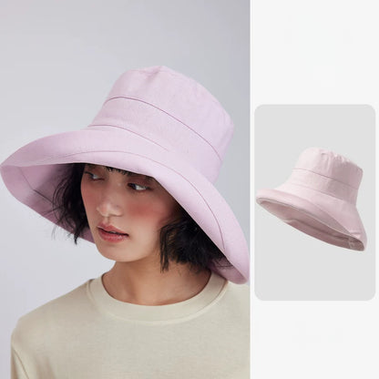 Woman wearing a light pink linen blend wide brim sun hat with a soft bucket-style silhouette