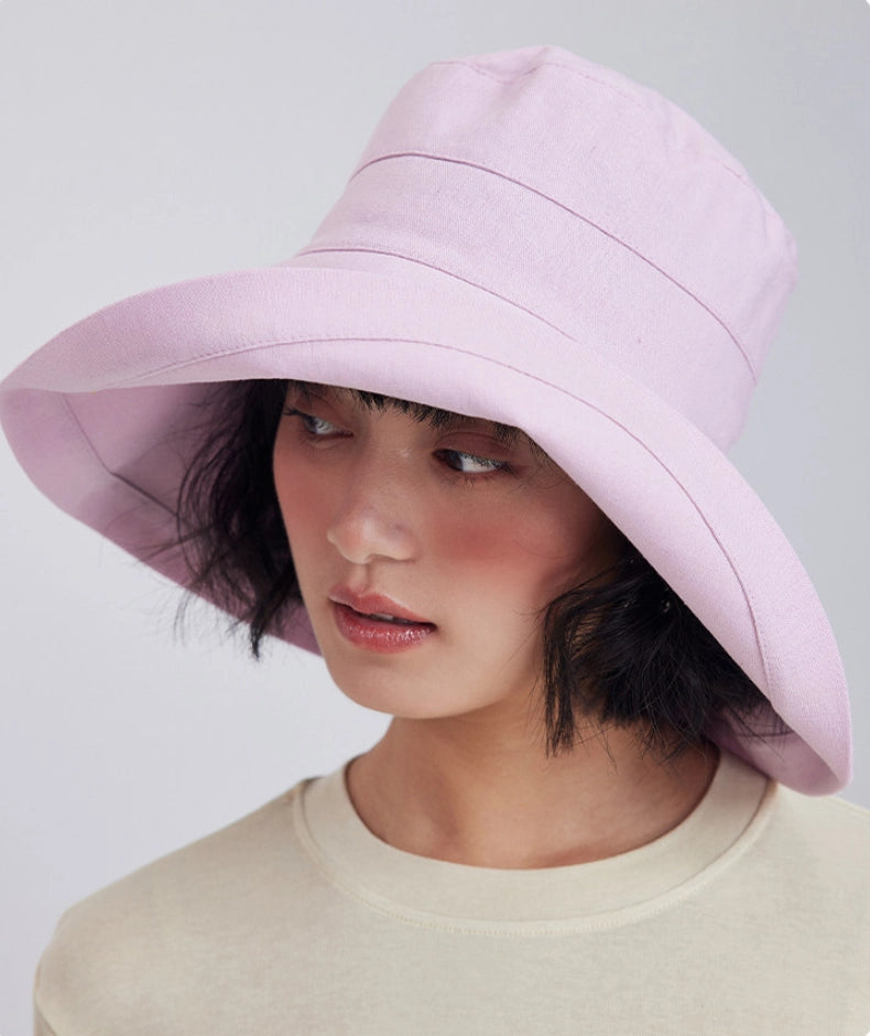 Side view of a light pink wide brim sun hat styled with a neutral summer top