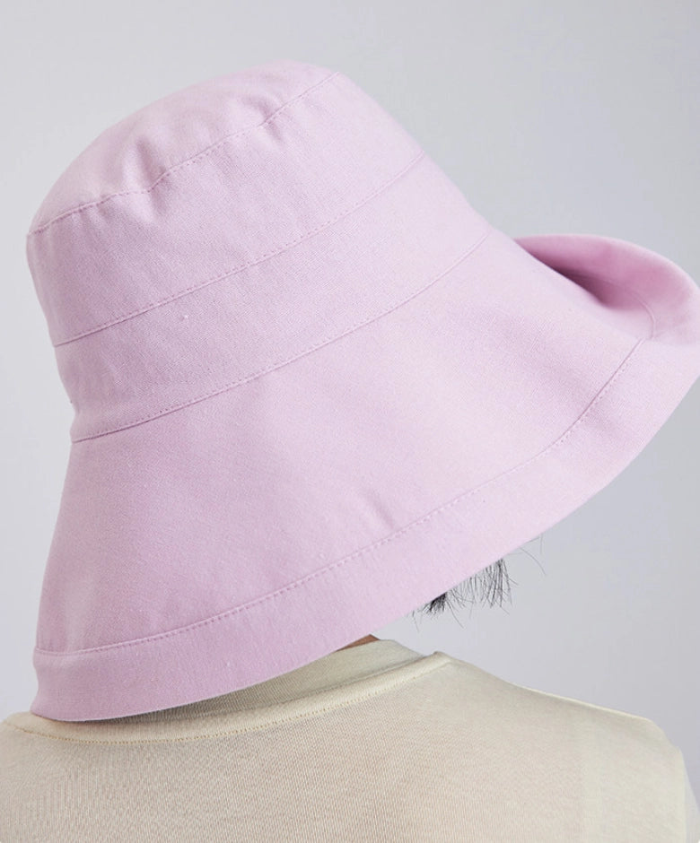Back view of a light pink linen blend sun hat showing its wide wrap-around brim