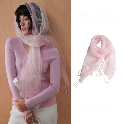 Woman wearing a light pink sheer mulberry silk fringe scarf over a tonal knit top