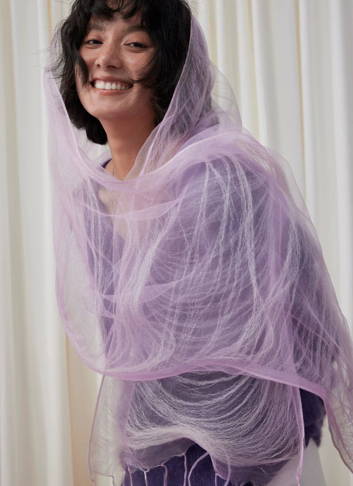 Woman wrapped in a sheer light purple silk scarf with soft flowing layers
