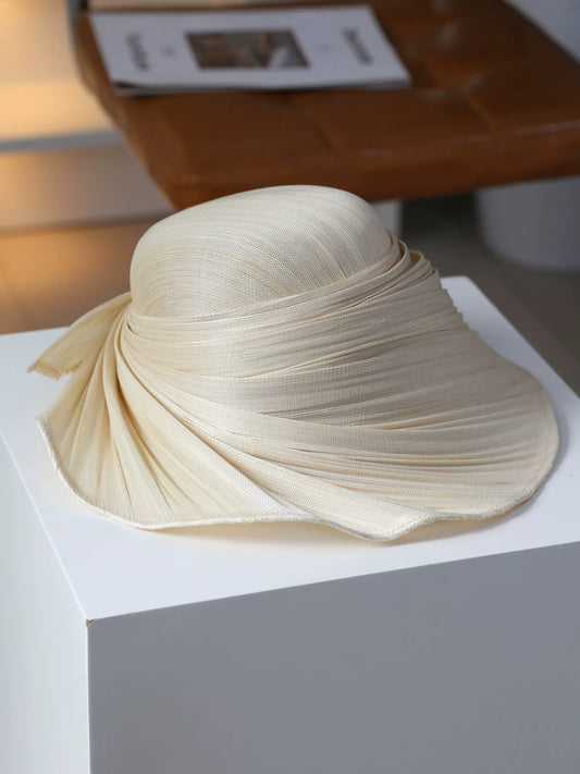 Ivory beige Buntal straw hat with pleated wide brim for resort styling.