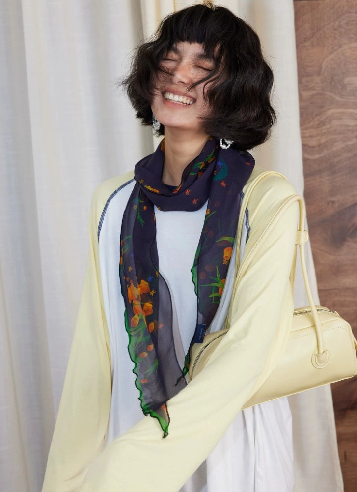 Long midnight blue botanical silk scarf draped as an elegant neck scarf