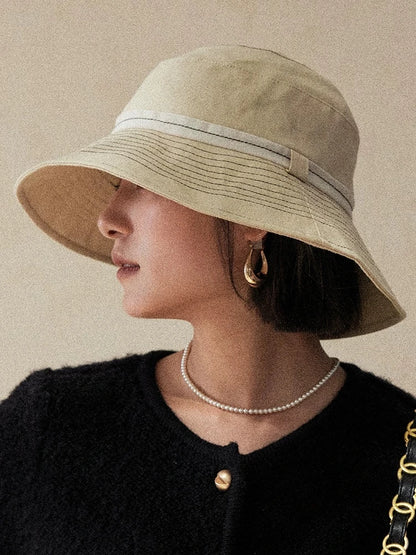 Milky apricot wide brim bucket hat styled for everyday sun protection and refined casual wear
