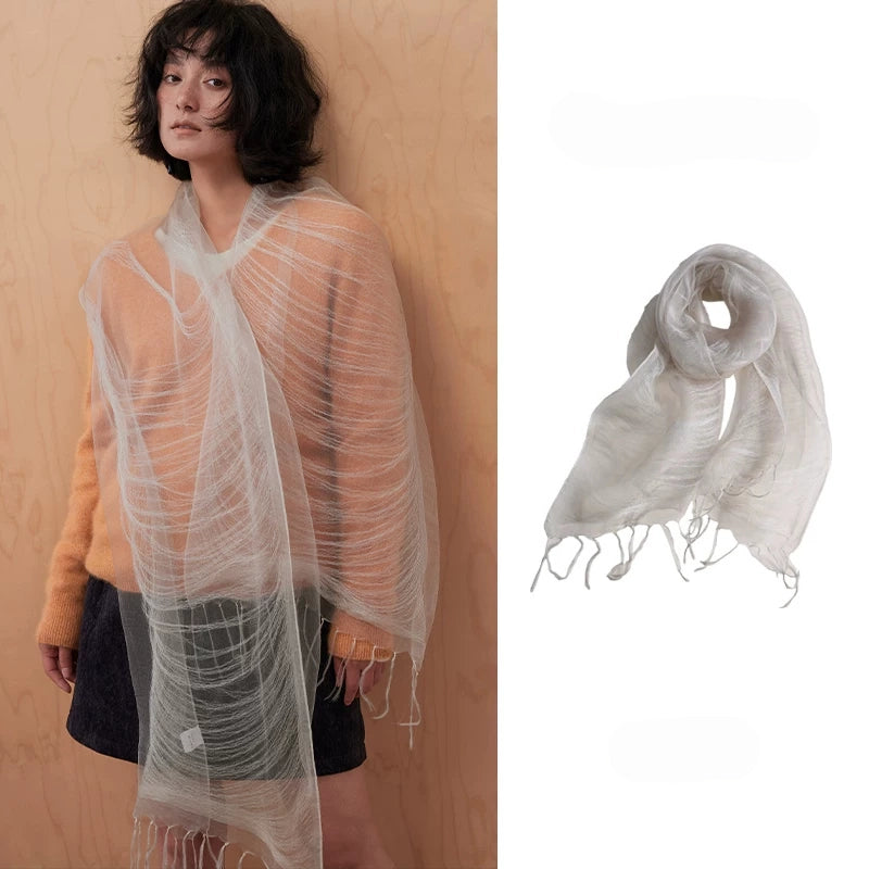 Woman wearing a mist gray sheer mulberry silk fringe scarf over an orange sweater