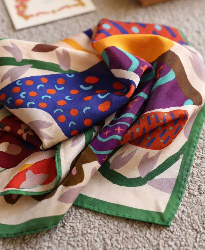 Close-up of soft mulberry silk scarf folds featuring colorful abstract butterfly wing details
