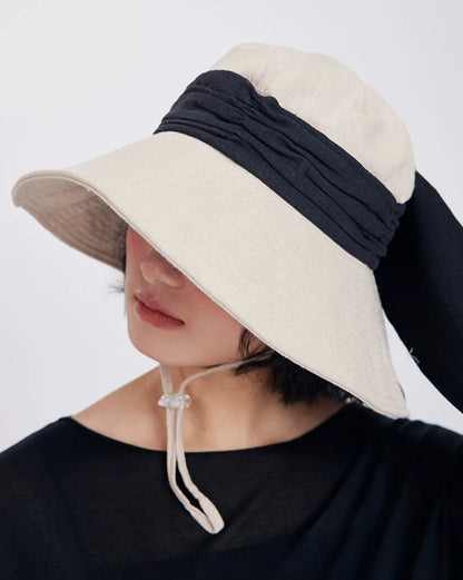Side view of ivory beige natural ramie sun hat with wide brim, black band, and casual women’s summer styling.