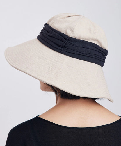 Back view of ivory beige foldable wide brim bucket hat with black contrast band and relaxed outdoor style.