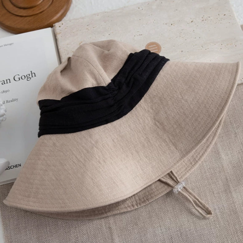 Ivory beige foldable ramie bucket hat with wide brim, wind cord, and breathable lightweight fabric for travel.
