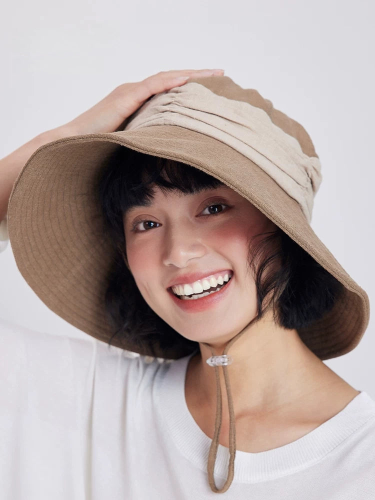 Model wearing a khaki ramie wide brim sun hat with soft contrast band for beach, travel, and outdoor wear.