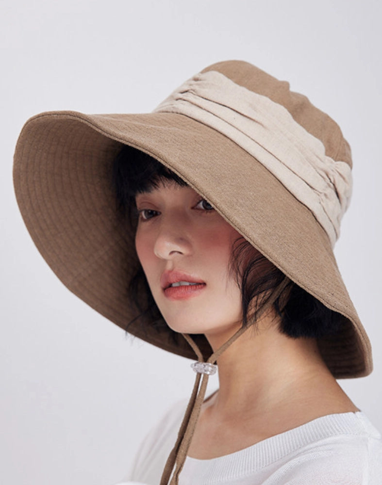 Side view of khaki natural ramie sun hat with wide brim and lightweight foldable design for travel.