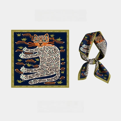 Navy blue and gold mulberry silk square scarf with orange and ivory leopard artwork, shown flat and tied