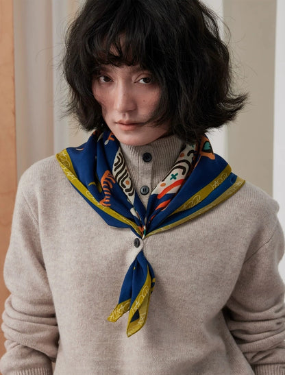 Smiling woman styling a navy blue and gold leopard silk square scarf in a long neck tie