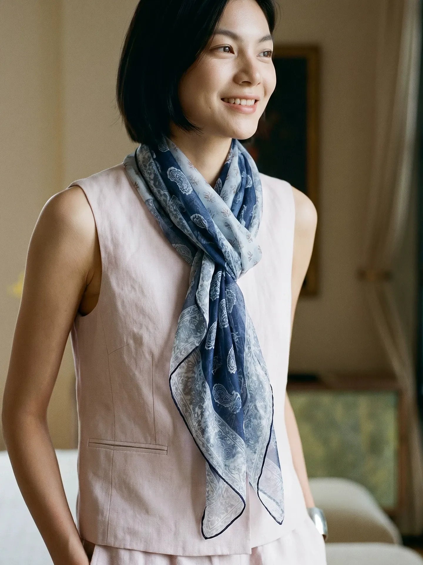Sheer navy floral silk chiffon scarf draped loosely around a woman’s neck