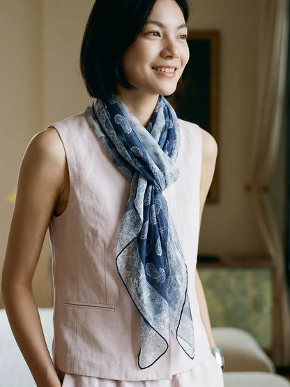 Sheer navy floral silk chiffon scarf draped loosely around a woman’s neck