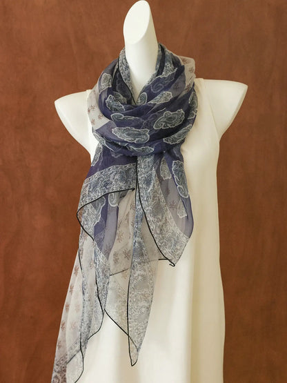 Long navy paisley silk chiffon scarf draped on a mannequin