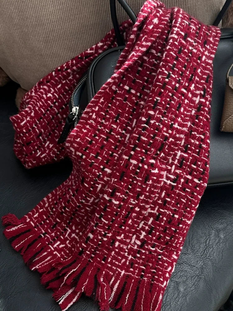 New Year red cashmere tweed scarf draped over a dark chair, highlighting its textured weave and long fringe.